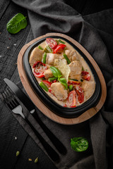 Baked chicken, with sun-dried tomatoes, green beans, cheese, vegetables in sour cream sauce. Restaurant menu.