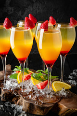 Grenadine cocktail, mango juice and champagne. Cocktail card.  Background black boards.