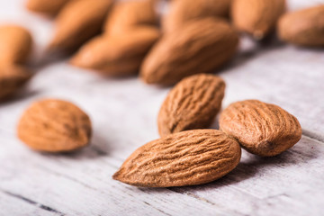 Almonds nut on white wooden table. Almond healthy raw food.