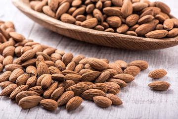 Almonds nut on white wooden table. Almond healthy raw food.