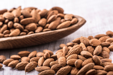 Almonds nut on white wooden table. Almond healthy raw food.