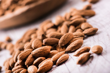 Almonds nut on white wooden table. Almond healthy raw food.