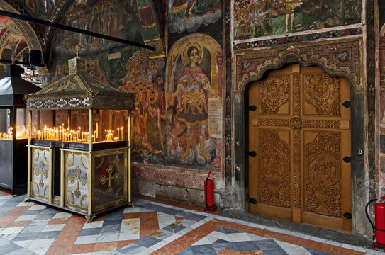 A beautiful church "Assumption of Virgin Mary&rdquo; in the churchyard with place for installation of candles in the Troyan Monastery, Oreshak village, Bulgaria  