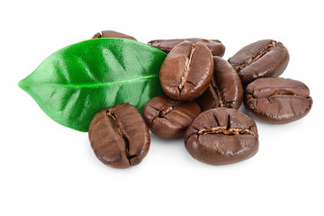 Heap of roasted coffee beans with leaves isolated on white background.