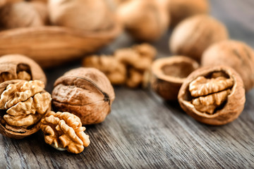 Whole walnuts on dark board, Walnut kernels in wood rustic bowl.