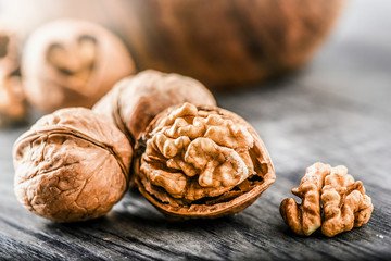 Whole walnuts on dark board, Walnut kernels in wood rustic bowl.
