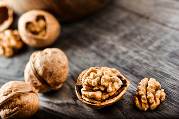 Whole walnuts on dark board, Walnut kernels in wood rustic bowl.