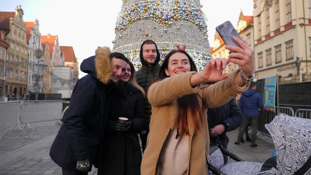 Hang out friends young people in city center take selfie phone picture near christmas tree in Wroclaw Poland