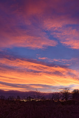 A dramatic and colourful Sunset over the Farmland and trees of the rural community of Colliston in Angus on a Winters night in January.