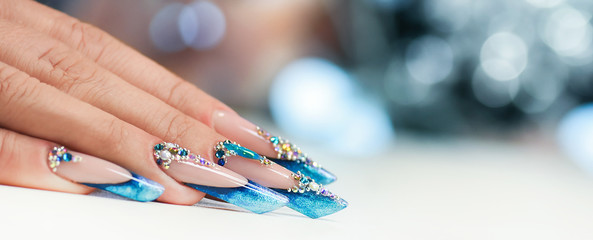 Winter nail art polish, Nails gel technique, Sparkling blue colour background, Russian almon nail shape - obrazy, fototapety, plakaty