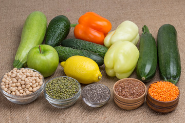 Set of balanced nutrition products: chili, pepper, lemon, apple, avocado, burlap, lentils, flax seed, kinoe, chickpeas.  Natural vegetarian source of protein, calcium.