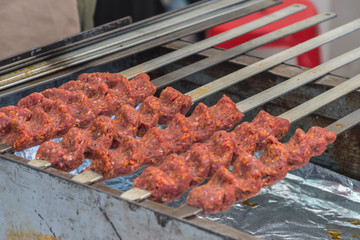 Adana kebab (ground lamb minced meat on skewer on grill over charcoal).Chef preparing traditional authentic Turkish shaworma. Middle eastern cuisine. Handmade specialty street food market with spices