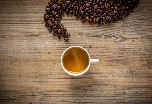 tazzina di caffe espresso con vapore fatto con chicchi di caffe vista dall'alto