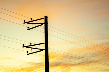 Electric pole shape against the sunset orange sky. Mobile communication, internet. electricity...