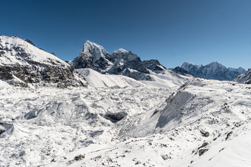 Ngozumpa glacier with the Cholatse peak in the background during a winter day in  from Gokyo in the Himalaya in Nepal