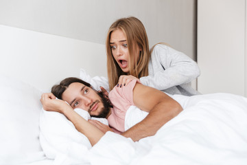 Beautiful young couple laying in bed