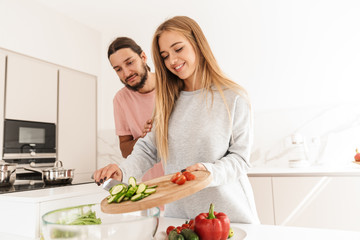 Cheerful lovely couple cooking healthy meal together