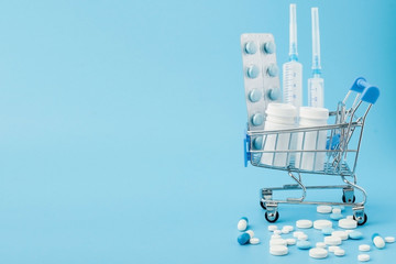 Pharmacy medicine. Shopping cart with pills and medical supplies.