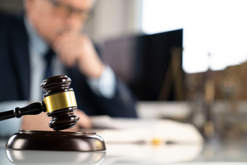 Consultation with a lawyer concept. Attorney at the office. Mallet and documents on the glass table.