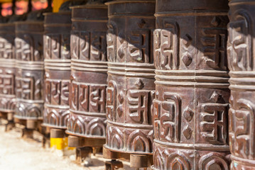 Praying drums. Line of vintage copper praying drums with sanskrit symbols.