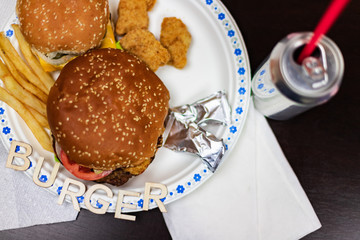 Delicious burger with fries on white plate. Word burger on the plate.
