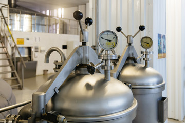 Manometer on the cylinder with gas in and hop dispenser in modern brewery. Close-up