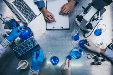 top view workspace in laboratory with microscope, laptop, and laboratory tools