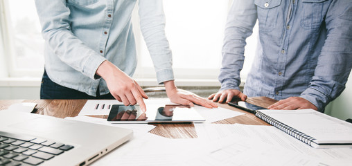 Website developers working using laptop at the office on wooden table.