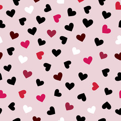 Black, white, pink, red hearts on light pink background. Seamless nice pattern for Valentine day. Good for packaging, wrapping, textile.