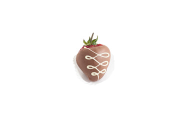 ripe red strawberries in dark chocolate with patterns in a paper basket isolated on white background