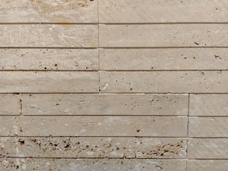 Stone wall with lines as tiles as an interesting design wallpaper or background for interior or exterior surface coverage