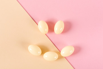 Composition of pills and capsules on a pink background in the form of a smile. Happy emotions. Psychological help.