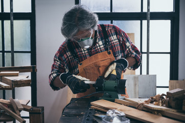 old carpenter man working in carpenter studio