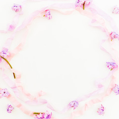Floral frame of hyacinth flowers, petals and tapes on white background. Flat lay