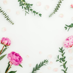 Floral frame of pink peonies, roses and eucalyptus branches on white. Flat lay