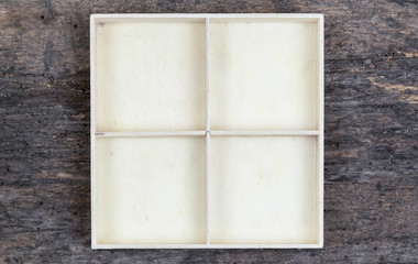 A white empty wooden box with compartments on a wooden background. place for goods in the store, jewelry or small things