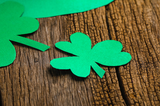 Happy Saint Patrick's mockup of handmade felt hat shamrock clover leaves and confetti on wooden table
