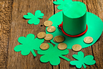 Happy St Patricks Day green leprechaun hat with gold covered chocolate coins on dark wood...
