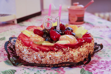 Torta di compleanno alla frutta con candeline 61 anni 