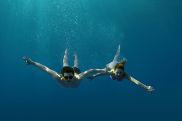 Young guy and girl dive in the tropical sea