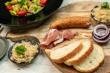 delicious German traditional specialties, Tyrolean ham, maultaschen, sauerkraut, fresh slices of baguette