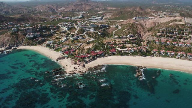 Jose del Cabo Palmilla homes and coast aerial Mavic 2 Zoom H.264. Tilt up to reveal mountains. Turquoise water and coral reefs. High Angle