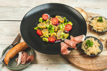 delicious German traditional specialties, Tyrolean ham, maultaschen, sauerkraut, fresh slices of baguette
