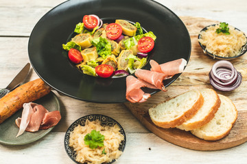 delicious German traditional specialties, Tyrolean ham, maultaschen, sauerkraut, fresh slices of baguette
