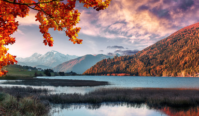 Wonderful Alpine Landscape in Sunny day. Colorful Autumn scene. Picture of wild area. Stunning Scenery during sunset, Fantastic Colorful clouds over the mountain lake in alps.