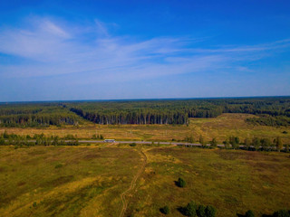 Bird's eye view of the forest, clouds and forest road