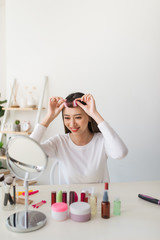 young beautiful woman applying her make-up