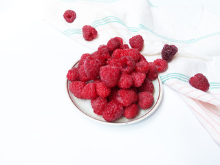 Raspberries on the plate  juicy , vegan , tasty berry  on white background , raw, fresh, natural, summer, food photo with a retro towel