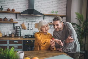 Good-looking elderly lady in yellow looking contented
