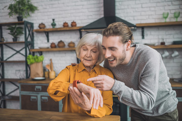 Good-looking elderly lady in yellow feeling great with her son